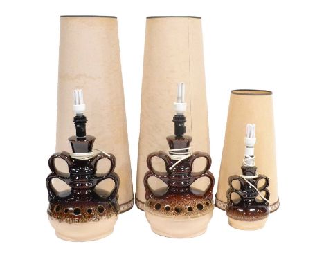 Three fat lava lamps with original shades, a pair in treacle and pale brown glaze with border of pierced holes, pair of handl