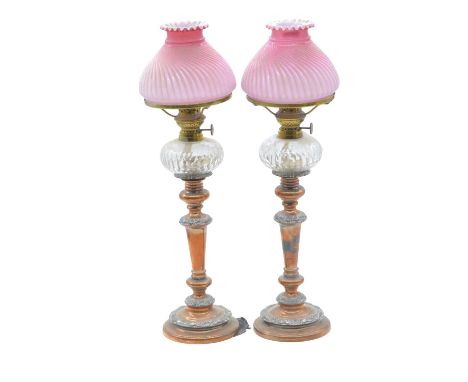 Pair of electroplated candlesticks, with peg lamp fitments, and pink tinted wrythen-moulded shades, 52cm overall.Qty: 2Condit