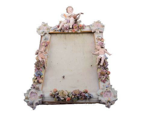 Dresden porcelain easel mirror, decorated with cherubs and encrusted with flowers, badly damaged, 44x31cm.