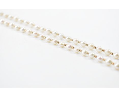 A 9ct gold and cultured pearl necklace. The necklace formed of cultured pearls 4mm - 5mm off round having gold bead spacers. 