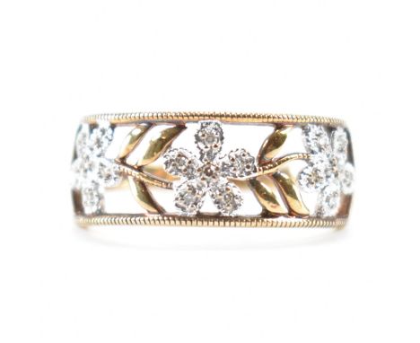 A hallmarked 9ct yellow gold &amp; diamond daisy chain ring. The ring having a head of punched floral design embellished with