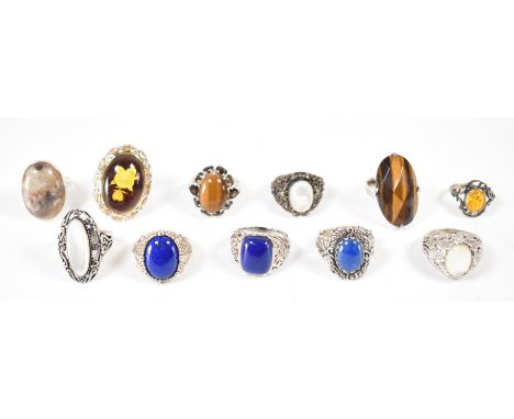 A group of silver stone set dress rings. The lot to include; faux amber cabochon, punched scrolling foliate setting, split sh