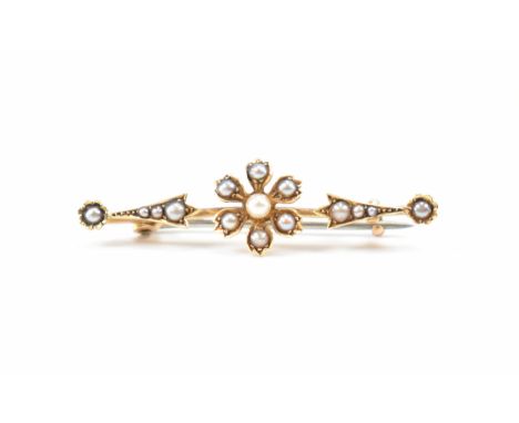 A 19th Century Victorian gold and seed pearl bar brooch. The brooch having a flower to the centre of the bar being set throug