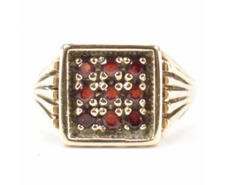 A hallmarked 9ct gold and garnet panel ring. The ring with a square head set with round cut garnets to stylized&nbsp; fan sho