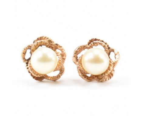 A pair of hallmarked 9ct gold and cultured pearl stud earrings. The earrings having textured mounts and set with cultured pea