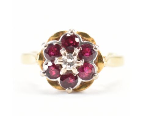 A vintage 18ct yellow gold, ruby &amp; diamond floral cluster ring. The ring having a central round brilliant cut prong set d