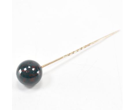 A 19th Century Victorian bloodstone and gold stick pin. The pin having a large bloodstone orb finial to the top, the pin with
