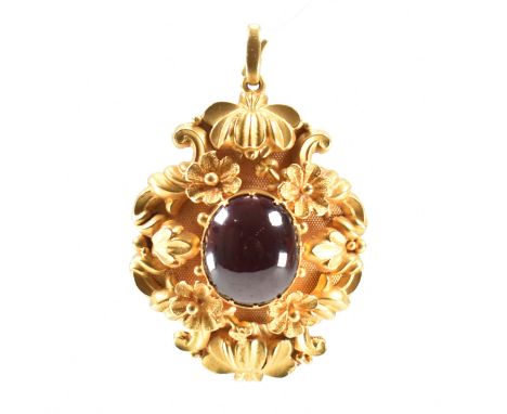 A 19th Century Victorian gold and garnet mourning pendant. The pendant set with an oval garnet cabochon set within a scrolled