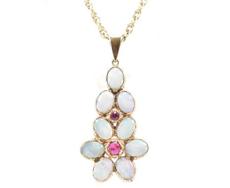 A hallmarked 9ct gold and opal and ruby pendant necklace. The necklace having a rope twist chain with a gold pendant set with