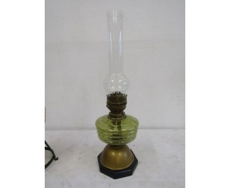 A yellow glass brass based oil lamp