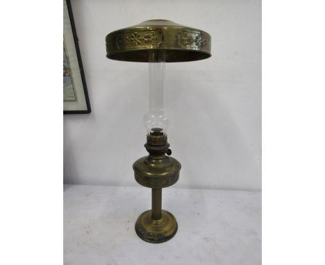 A brass base oil lamp with brass shade to the top