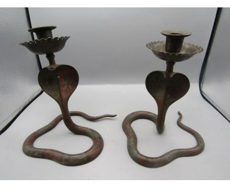 A pair of brass cobra candle stick holders