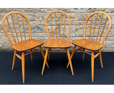 A set of three Ercol Windsor spindle-back chairs, in elm and beech, c.1970, Ercol labels to rear of seats, (3).
