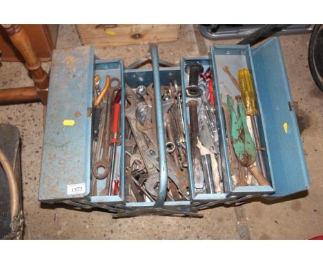 A metal cantilever tool box and contents to include spanners, mole grips, screw drivers etc.
