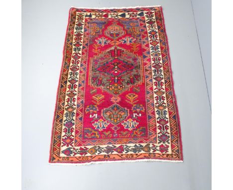 A red-ground Afghan rug. 204x130cmNice overall condition. Light signs of wear and some edging is frayed. 