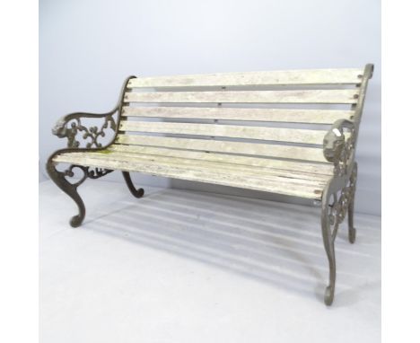 A teak slatted garden bench with cast iron ends, with lion decoration. 130x73x65cm. 