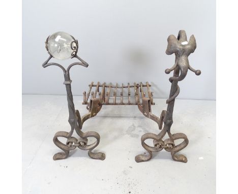 A pair of wrought Iron fire dogs, one topped with a crystal ball and the other with an elephant head, and an un-associated gr