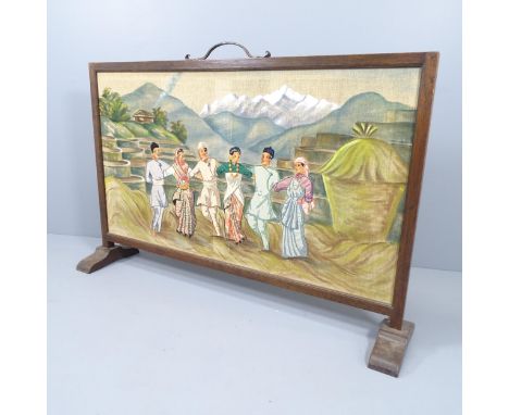 An oak framed fire screen with painted and embroidered panel depicting a rural oriental scene. 141x96x30cm. 