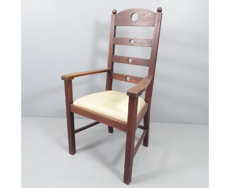 An Arts & Crafts oak ladder back armchair with heart and circle cut-outs. 