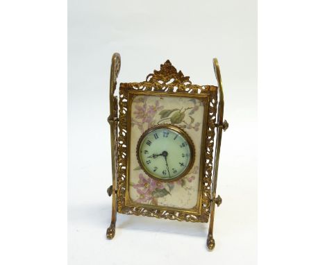 A VICTORIAN GILT METAL AND POTTERY OBLONG EASEL TYPE MANTEL CLOCK, the circular dial inset into a floral decorated porcelain 
