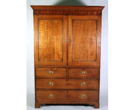 EARLY NINETEENTH CENTURY OAK AND MAHOGANY GARDEROBE, the moulded cornice above a crossbanded frieze and pair of cupboard door