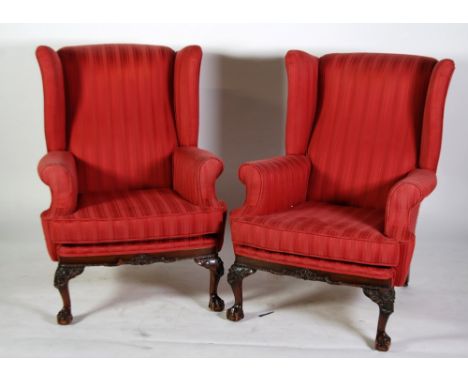 PAIR OF EARLY TWENTIETH CENTURY CHIPPENDALE STYLE OAK AND STAINED BEECH WING BACK FIRESIDE EASY ARMCHAIRS, with cushion seats