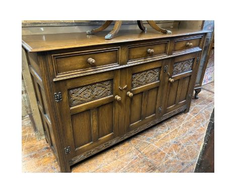 Solid Oak Sideboard, three drawers over three carved cupboards supported by short bracket legs panelled sides. approximately 
