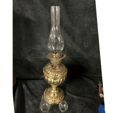 A brass oil lamp with inner flue but no outer shade.