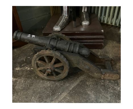 A cast iron scale model of a cannon on ridged wheels, 73cm long
