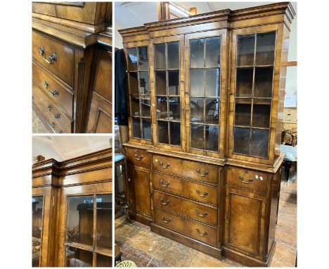 A step fronted glazed Mahogany veneer book case, four glazed doors over 4 central drawers and two smaller drawers over cupboa