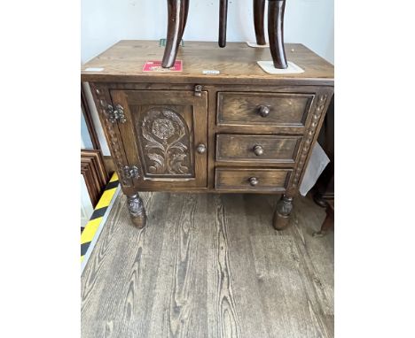 A carved oak cabinet with three drawers. Height 61cm, width 64cm and depth 38cm.Condition- some general wear to include surfa