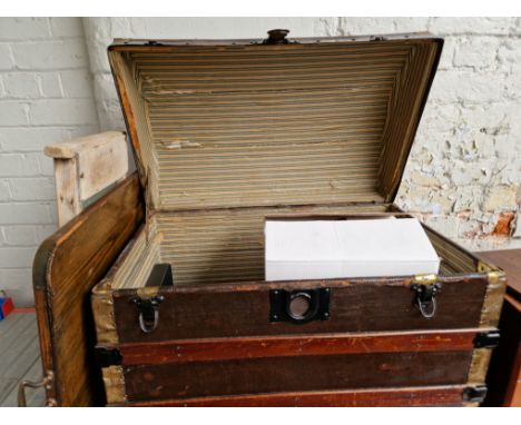 A domed trunk and contents including a tray, a wash board, 1930s china, meat plates, dishes. 