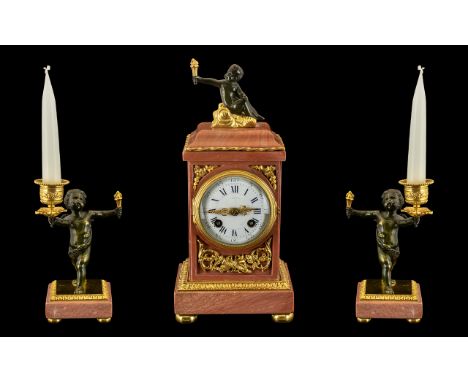 French Clock Garniture.  A pink marble and ormolu mounted clock garniture.  The case of rectangular form, surmounted by a sea