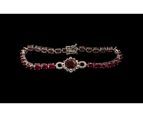 Ruby Line Bracelet with Central Infinity Motif, 23cts, a line of oval cut rubies with a solitaire, larger, oval cut ruby of 3