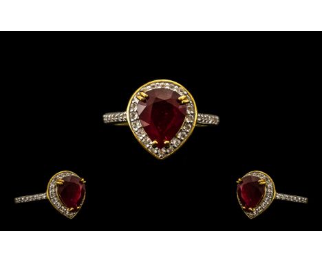 Ruby and White Topaz Halo Ring, a 4.5ct pear cut ruby of rich red, glowing colour, enhanced by the sparkling halo of .75ct of