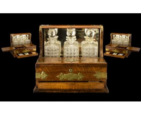 Fine Quality Oak Cased Antique Tantalus Compendium with mirror back and brass carrying handles fitted with three fine quality