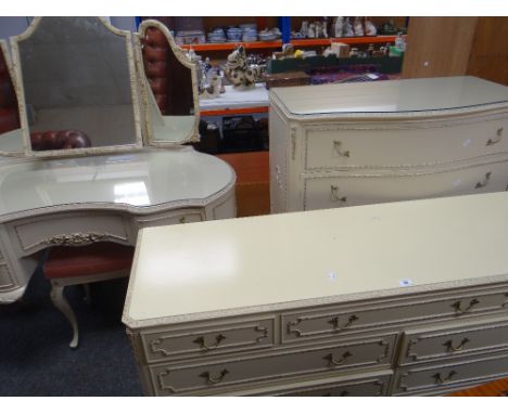 A vintage cream French-style six-piece bedroom suite comprising kidney shaped dressing table, serpentine front chest, long ch