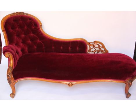 A Victorian carved walnut chaise lounge, with button back and upholstered in red drailon, on cabriole legs, 179cm
