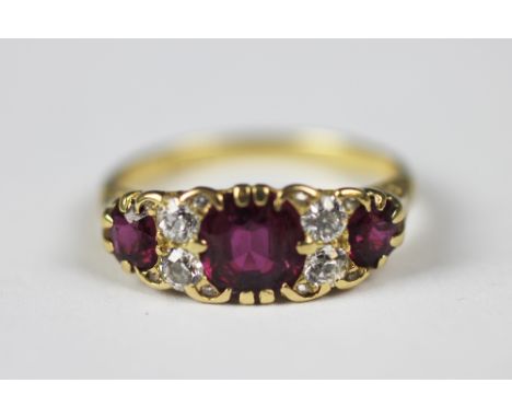 A ruby and diamond seven stone ring, in Victorian style, the three graduated rubies, each interspersed with two old cut diamo