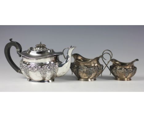 An Edwardian silver three piece tea service, Joseph Gloster Ltd, Birmingham 1907, of lobed oval form with embossed floral scr