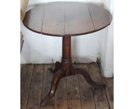 A George II oak tilt top table, with four plank top on a turned column and tripod base, 69cm H x 73cm diameter