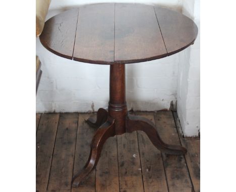 A George II oak tilt top table, with four plank top on a turned column and tripod base, 69cm H x 73cm diameter