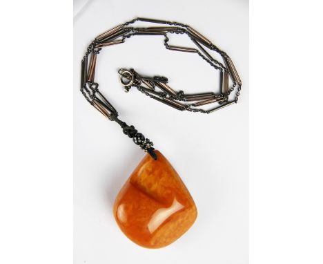 An Amber pendant and attached chain circa 1930, the large amber boulder pendant 6.5cm x 5.8cm (amber weight 50.8gms) suspende