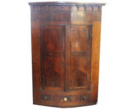 A George III mahogany bow front corner cabinet, with two drawers above a small drawer, with moulded cornice, 123cm H x 87cm W