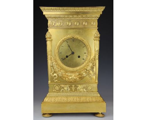 An early 19th century French Empire ormolu eight day mantel clock, Roman numeral dial within a laurel leaf surround, the rect