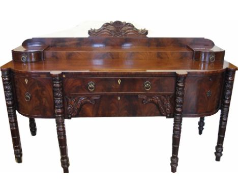 A George IV carved mahogany sideboard, the raised two tier back with two bow front drawers, above two central drawers and two