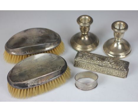 A pair of silver dwarf candlesticks, Birmingham 2004, a pair of silver backed brushes, a napkin ring and a silver trinket box