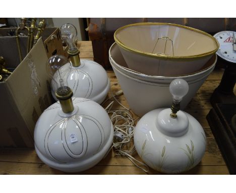A pair of large pottery table lamps with shades and a similar lamp.
