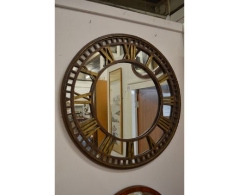 A large metal clock face mirror.