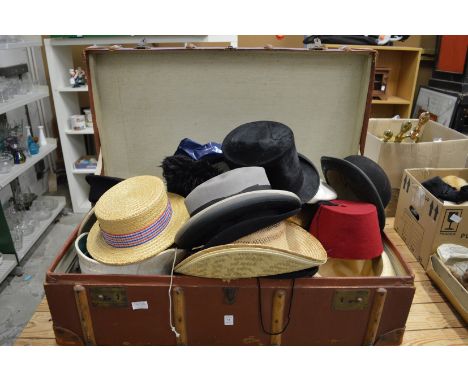 A large trunk containing numerous hats.